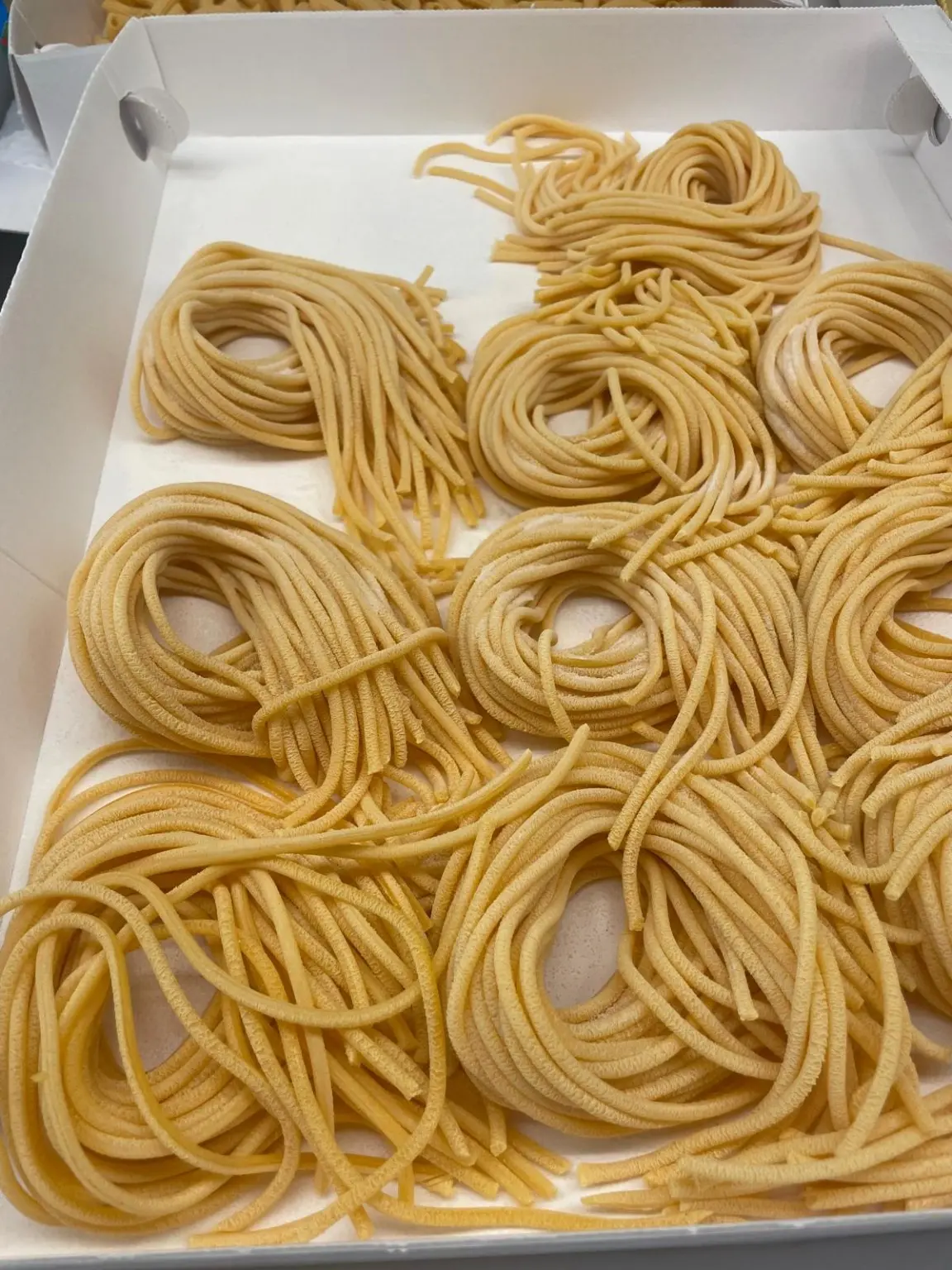Nidi di pasta lunga all'uovo esposti nel banco del Pane di Marty